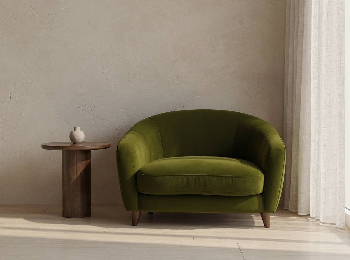 Replace only the beige boucle armchair with one deep olive velvet two-seat sofa. Preserve the exact room, camera angle, furniture placement, walnut side table, wall, curtain, lighting, shadows, geometry, and every unselected object; no text, logos, or watermark.