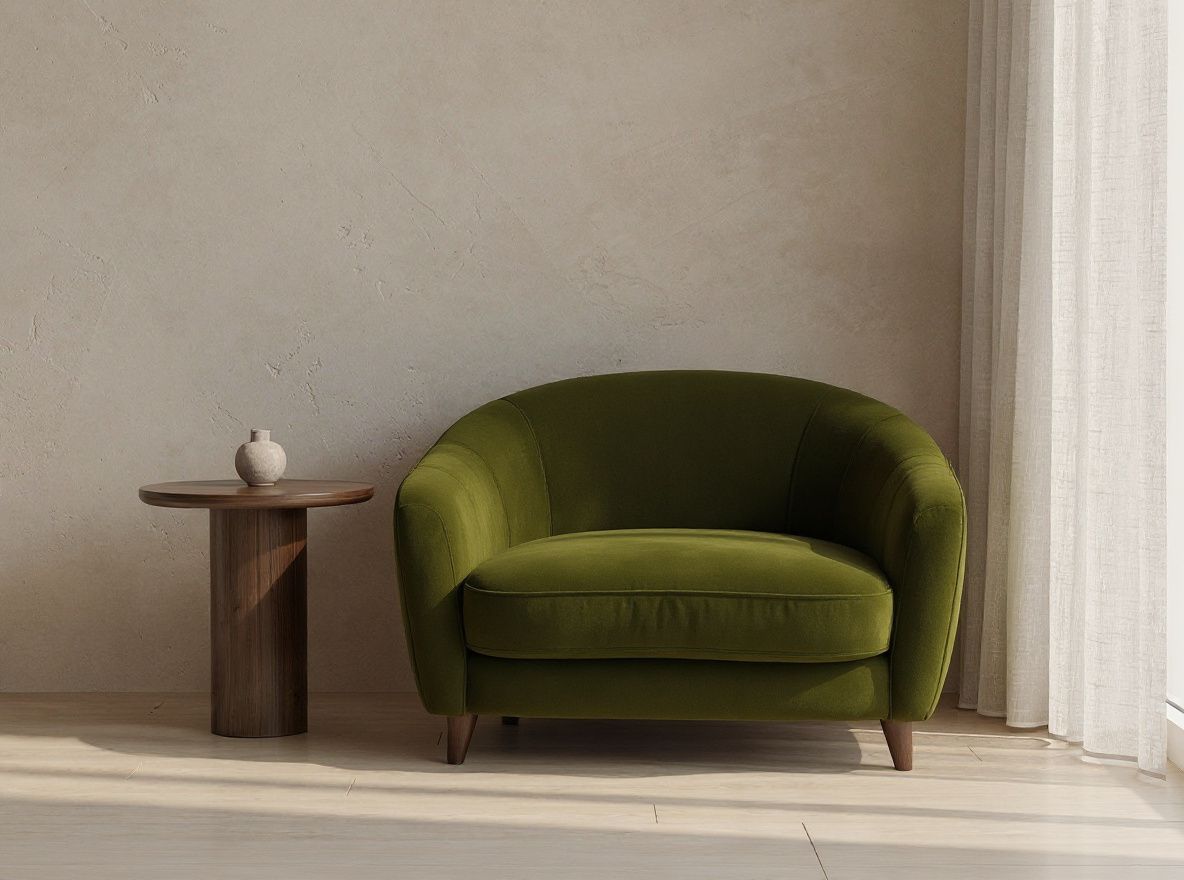 Replace only the beige boucle armchair with one deep olive velvet two-seat sofa. Preserve the exact room, camera angle, furniture placement, walnut side table, wall, curtain, lighting, shadows, geometry, and every unselected object; no text, logos, or watermark.